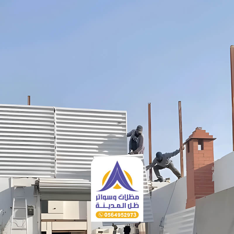 فريق العميل في مؤسسة ظل المدينة أثنا تركيب ساتر حديد باللون الابيض